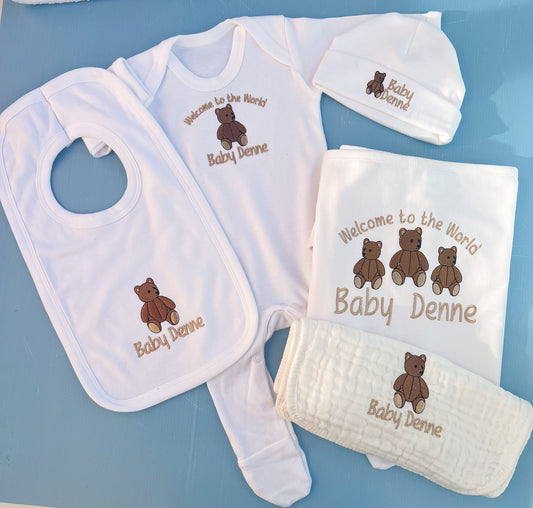 Baby gift set with bib, onesie, hat, and blanket on a blue background