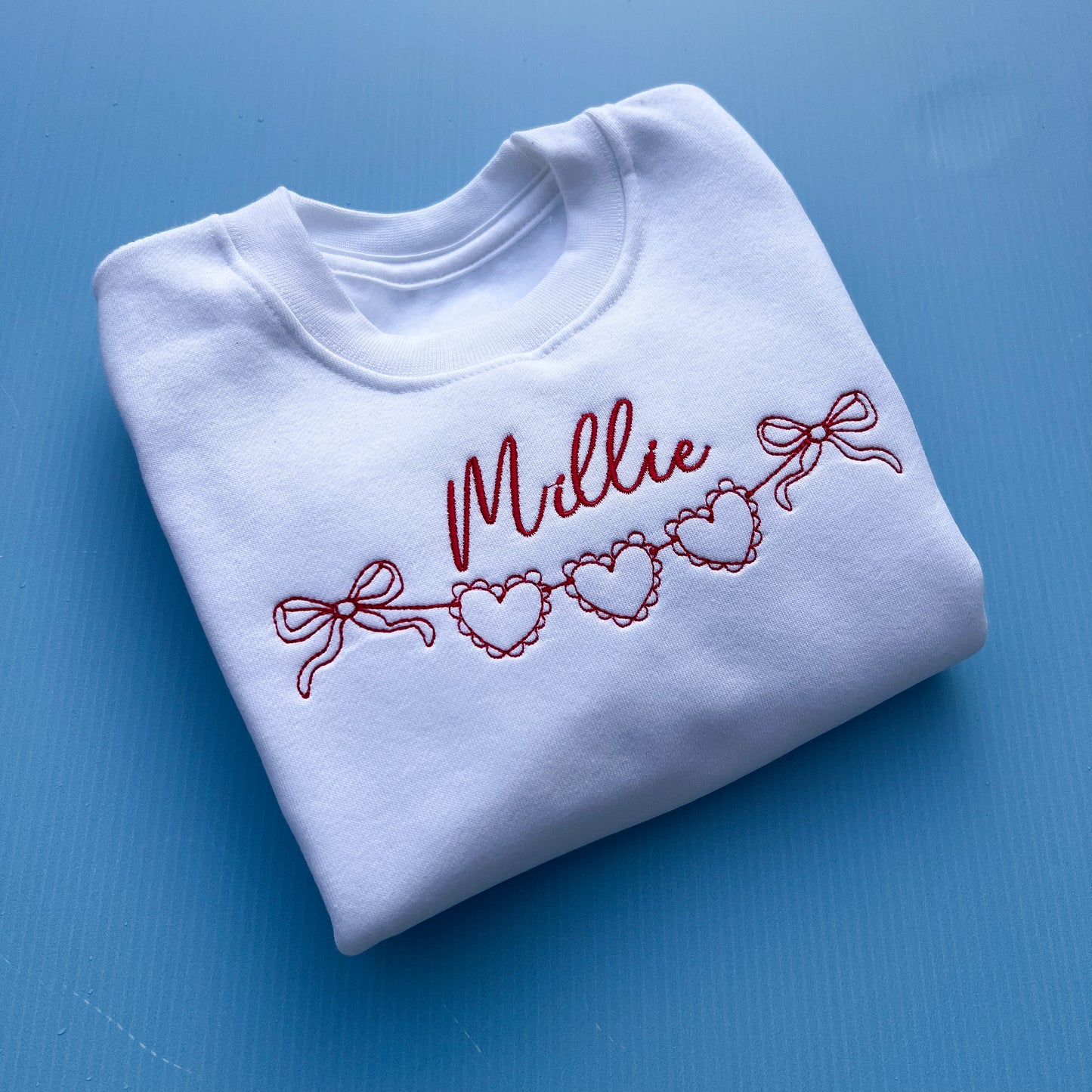 String of Hearts Sweatshirt with red heart embroidery