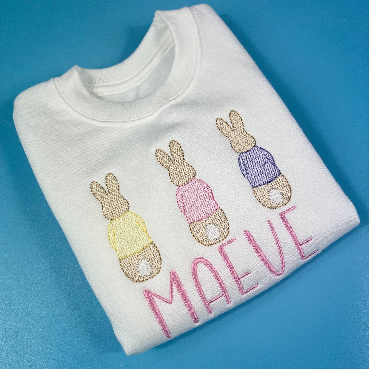 Close up of the embroidered 3 rabbits on a sweatshirt
