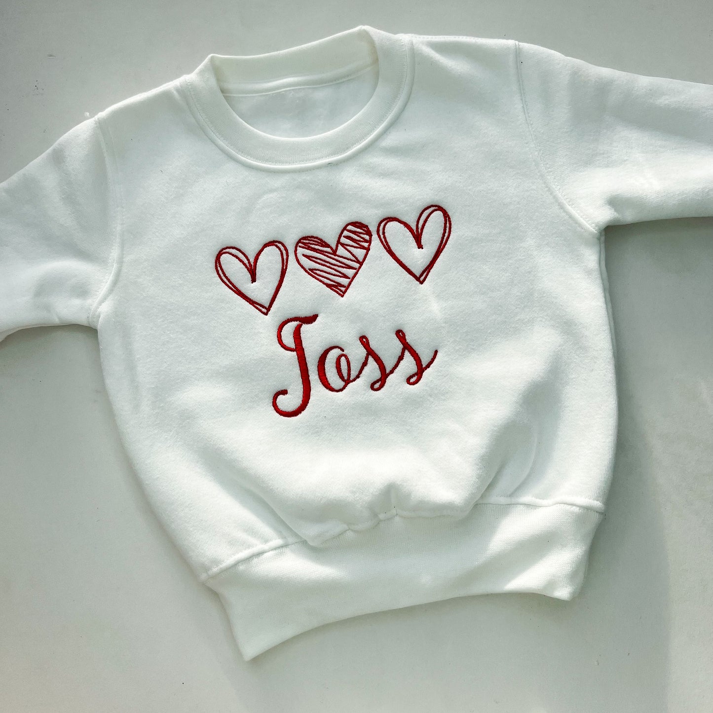 White jumper with red love heart embroidery