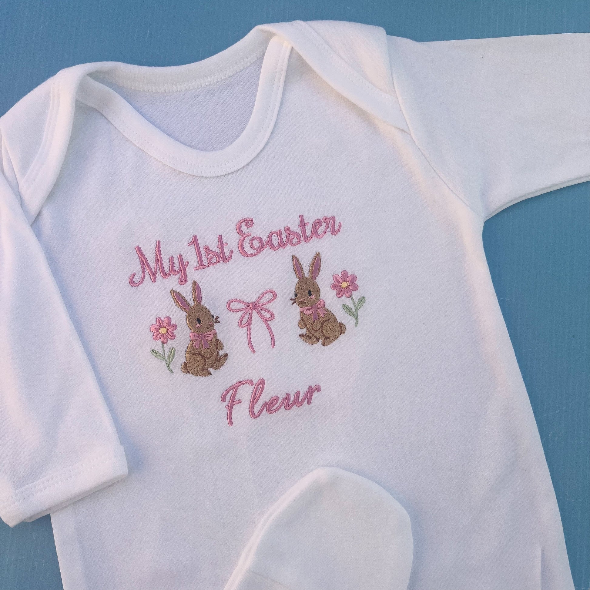 Baby romper with my first Easter embroidered in pink with a bunny, bow and some flowers 
