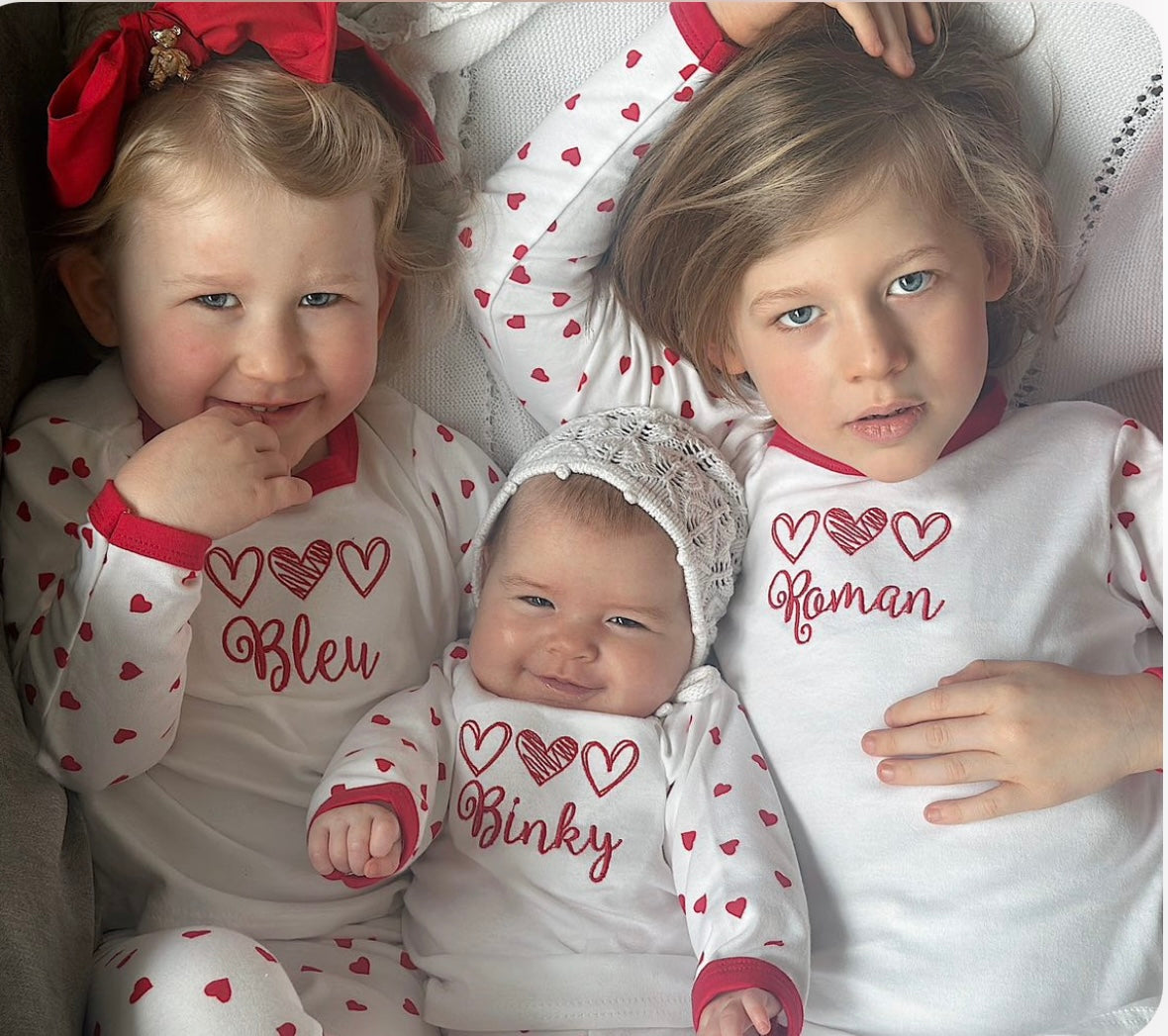 3 kids wearing Kids red and white valentine's pjs or  pyjamas with children's names embroidered personalisation. 3 heart Valentine’s Pyjamas. Great for 1st valentines day.