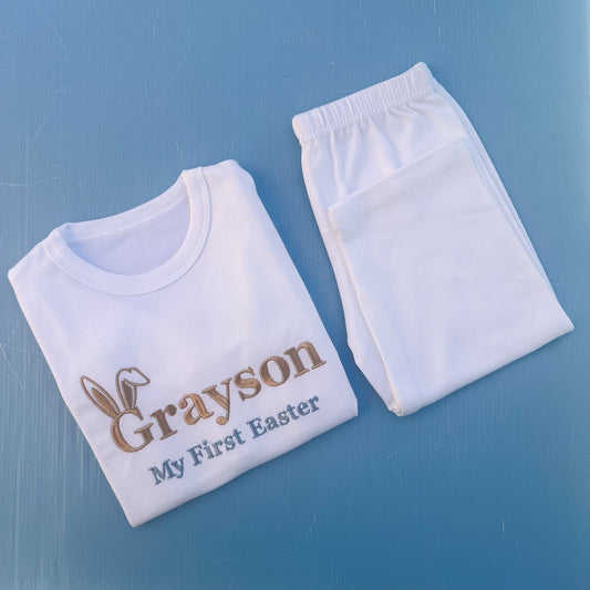White pyjamas with Grayson first Easter embroidered on with bunny ears 