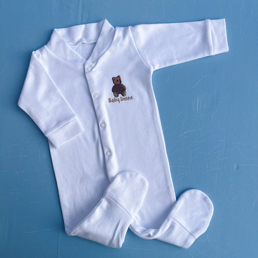 White baby onesie with a brown bear design on a blue background