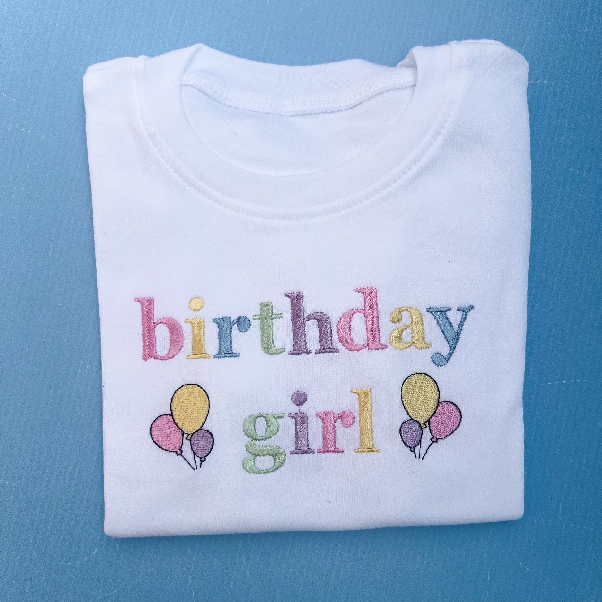 Folded birthday girl tshirt with pastels embroidery 