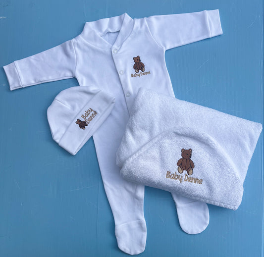 Baby clothing set with white outfit, hat, and blanket featuring a teddy bear and 'Baby Denne' text on a blue background.