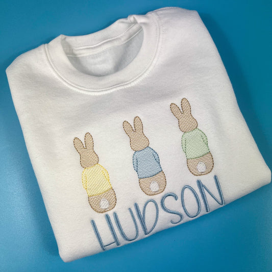 Close up of 3 bunnies embroidered on a white sweatshirt 