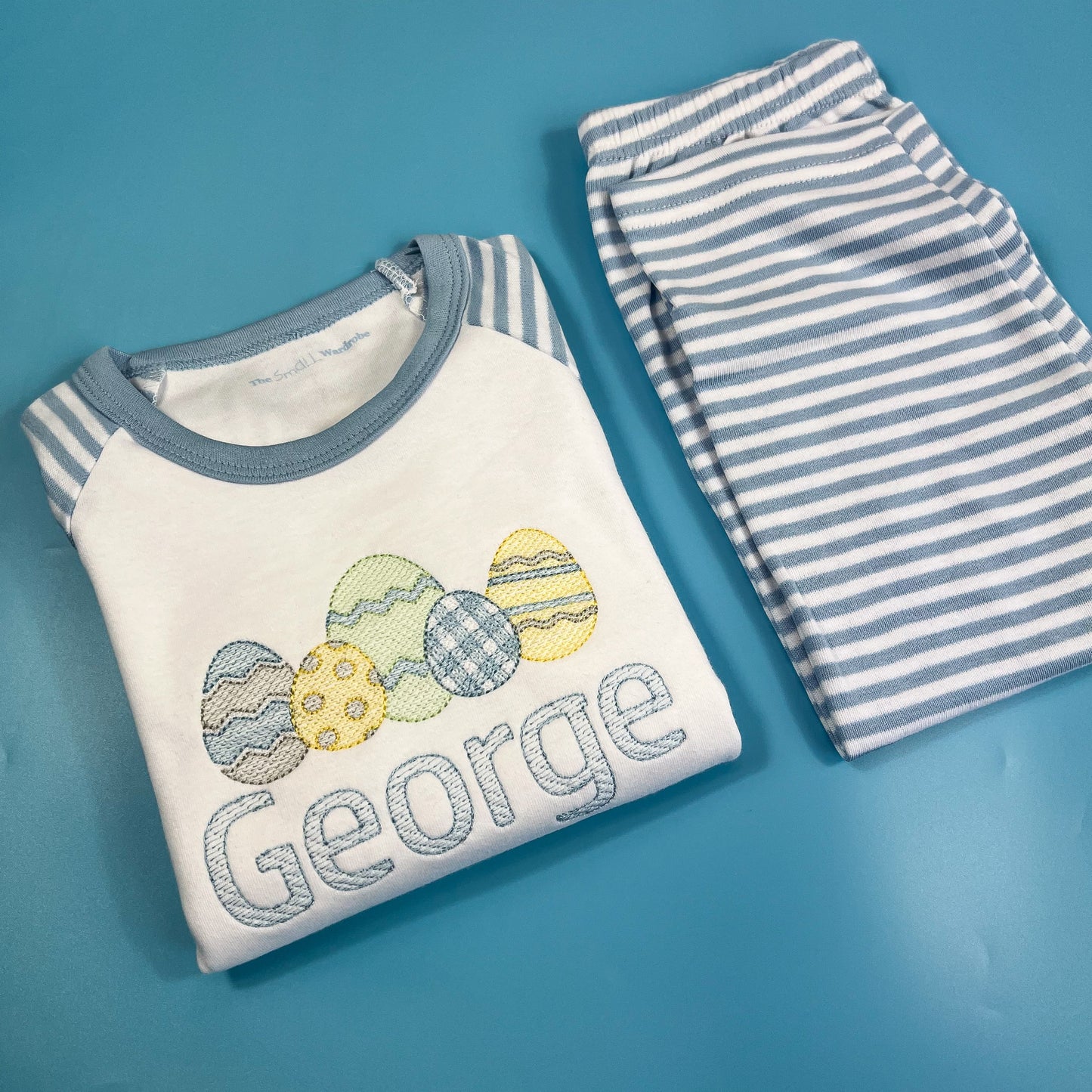 Children's outfit with 'George' embroidered on a blue background