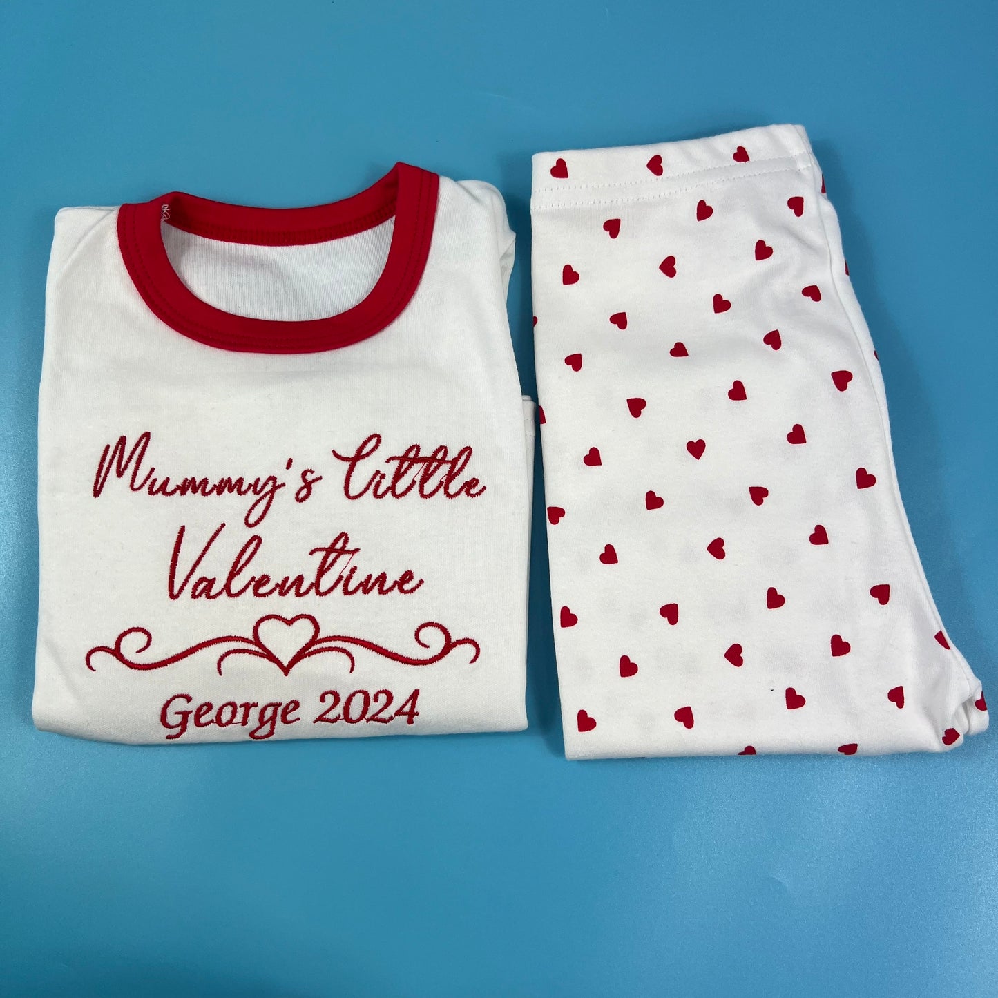 Children's pajama set with 'Mummy's Little Valentine' text and heart pattern on a blue background