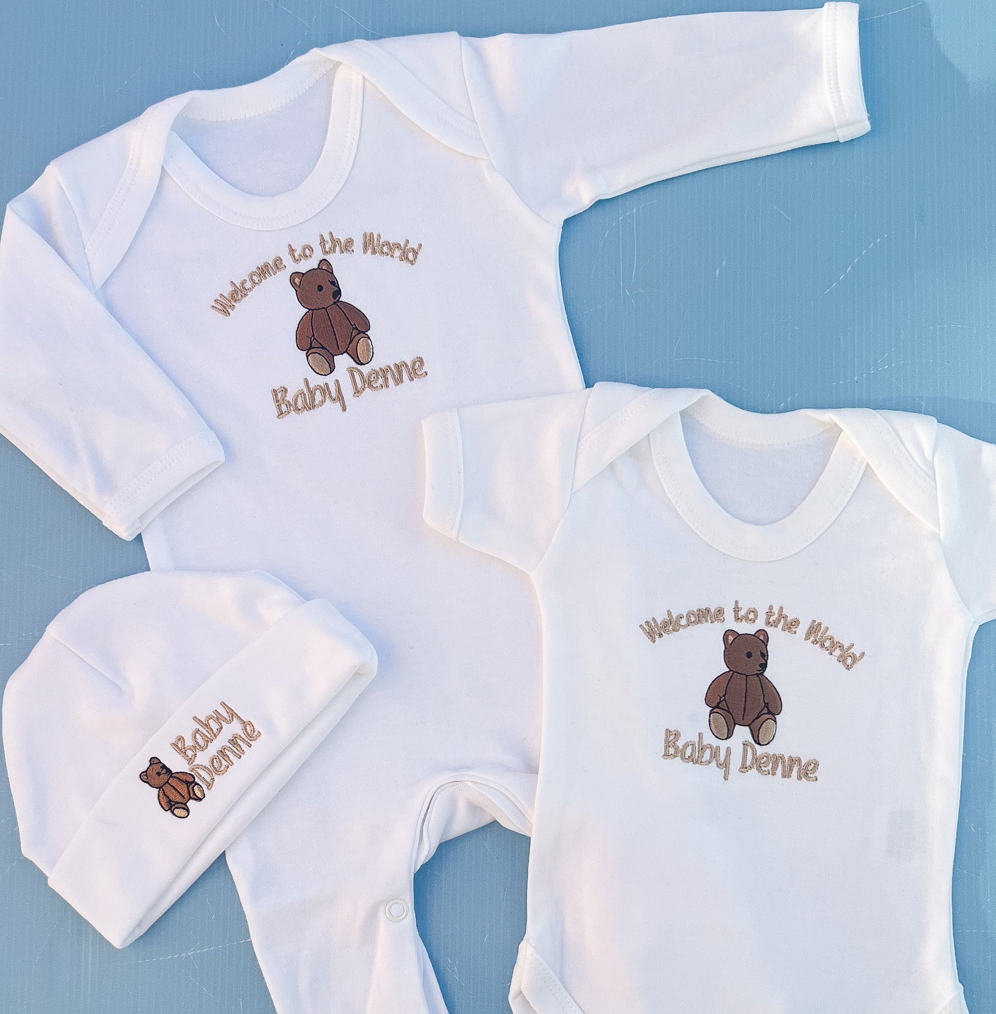 Close of f babygrow vest and hat with traditional bear embroidery 