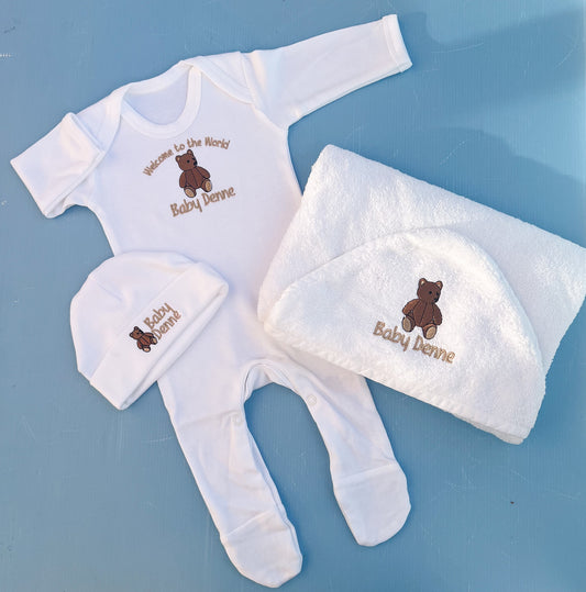 Baby clothing set with embroidered name on a blue background