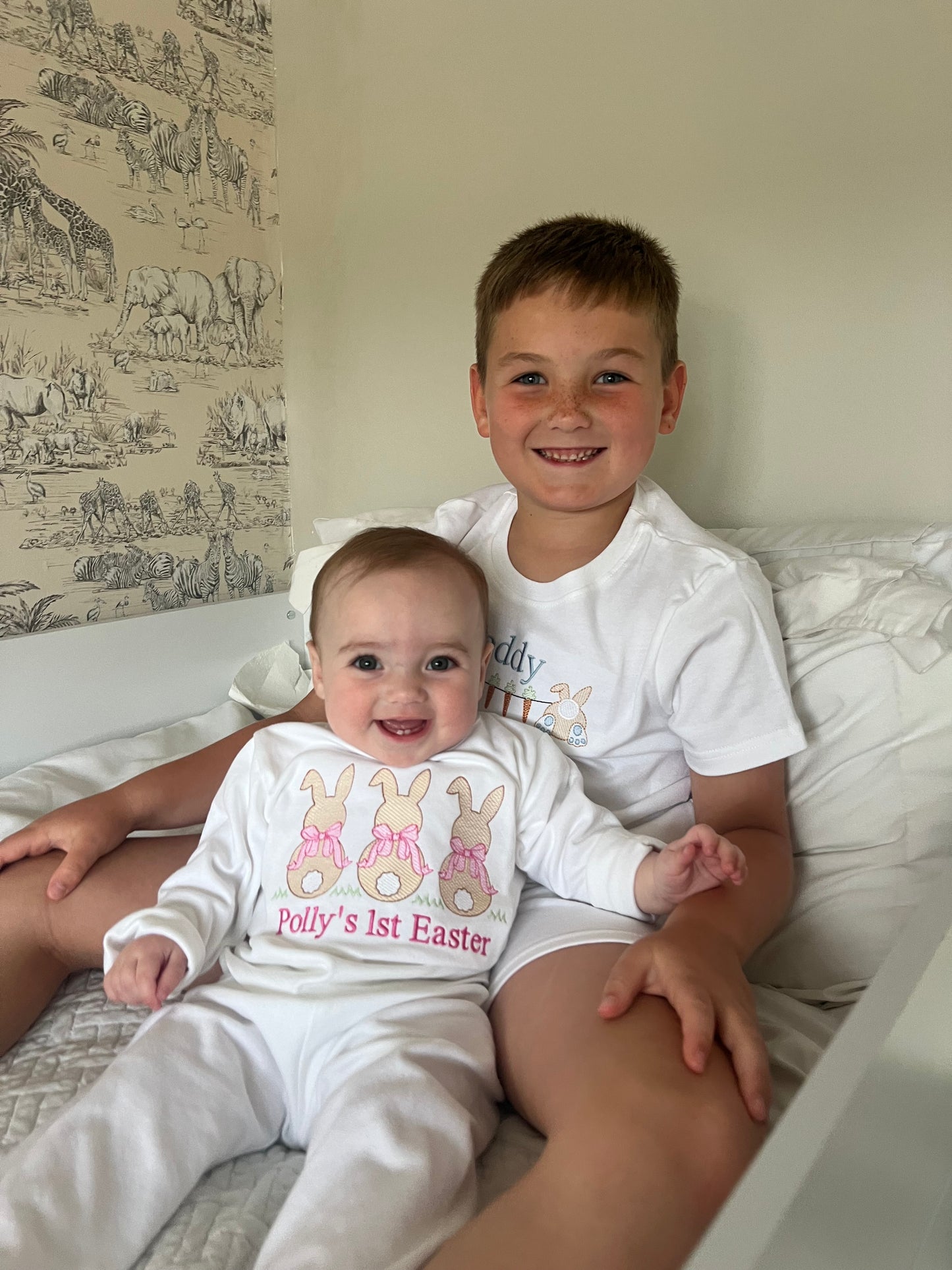Two children wearing Easter-themed outfits on a couch.
