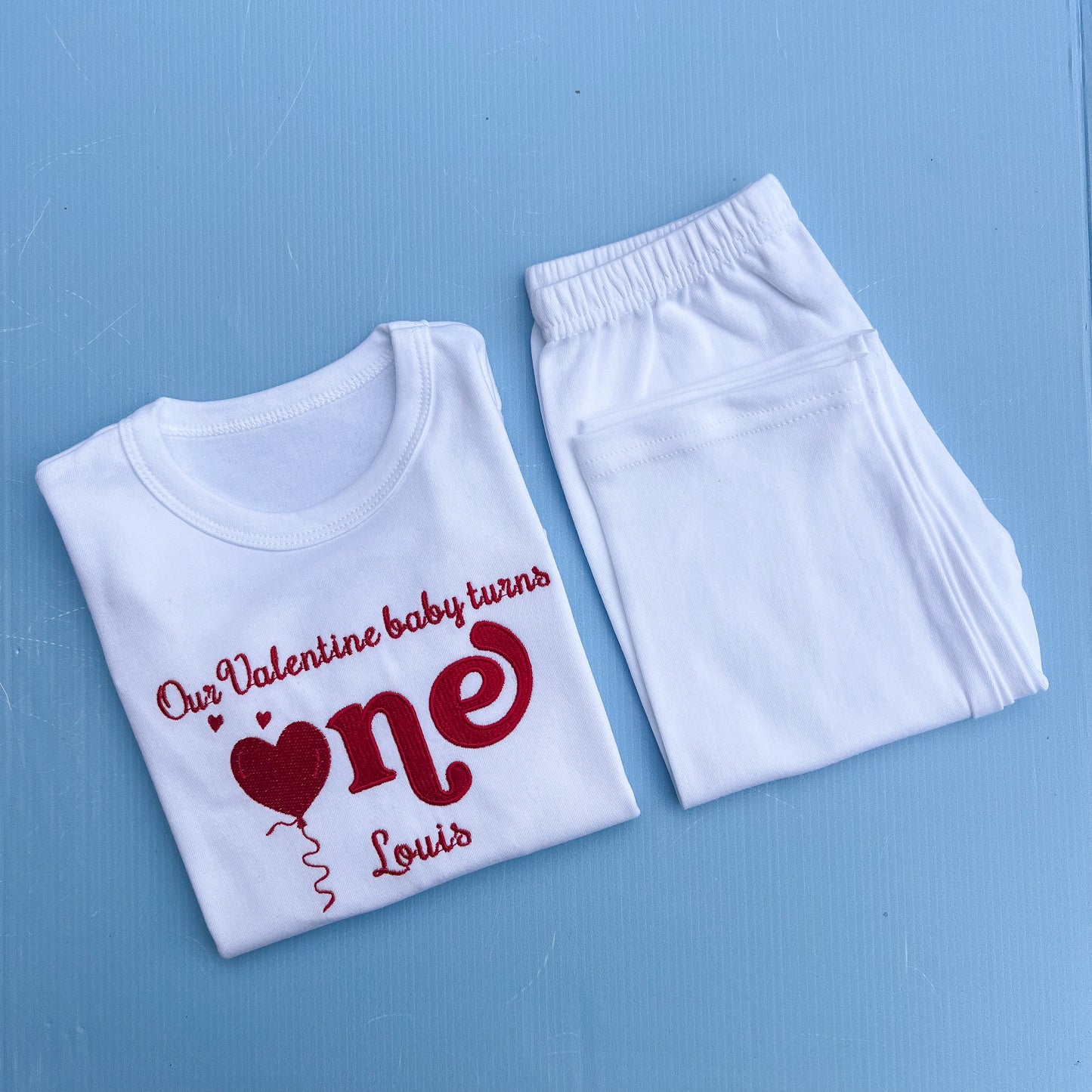 White t-shirt and pants with red text on a blue background