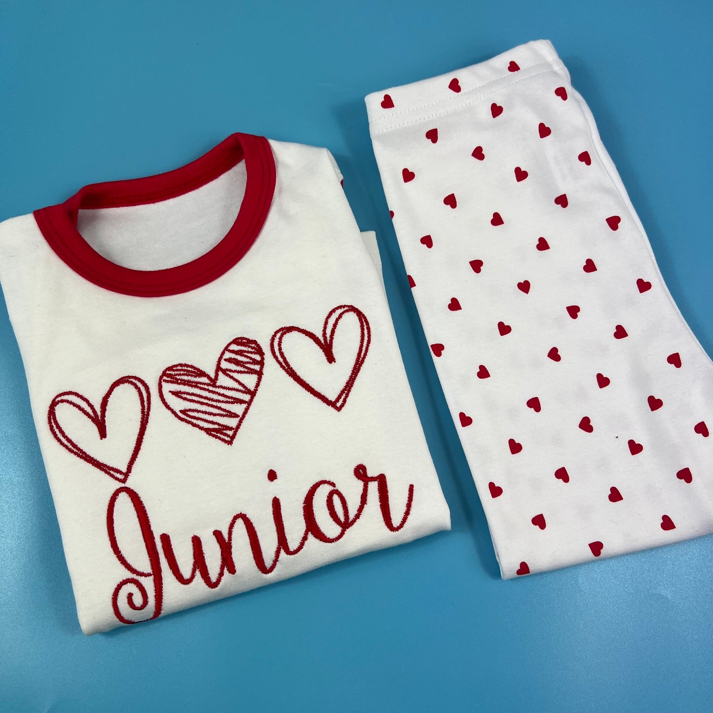 Kids red and white valentine's pjs or  pyjamas with children's names embroidered personalisation. 3 heart Valentine’s Pyjamas. Great for 1st valentines day.