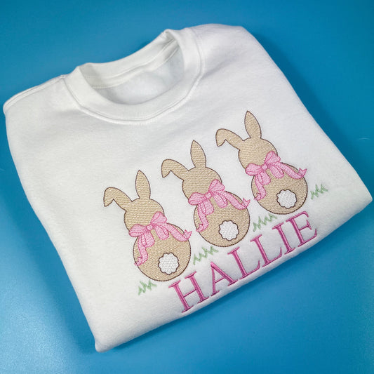 3 bunniess embroidered on a sweatshirt with pink bows and child’s name