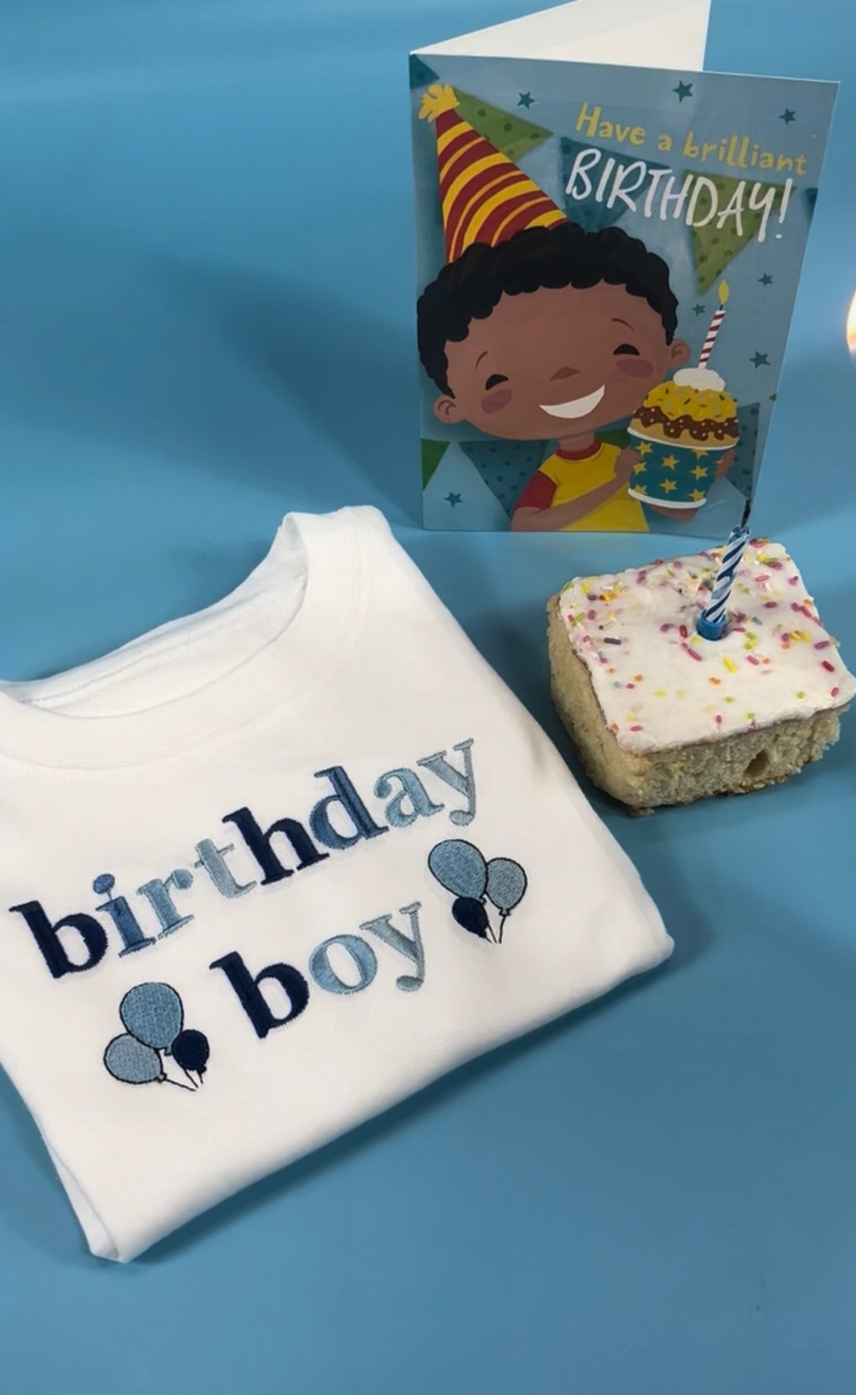 Folded birthday boy T-shirt with birthday cake and card 