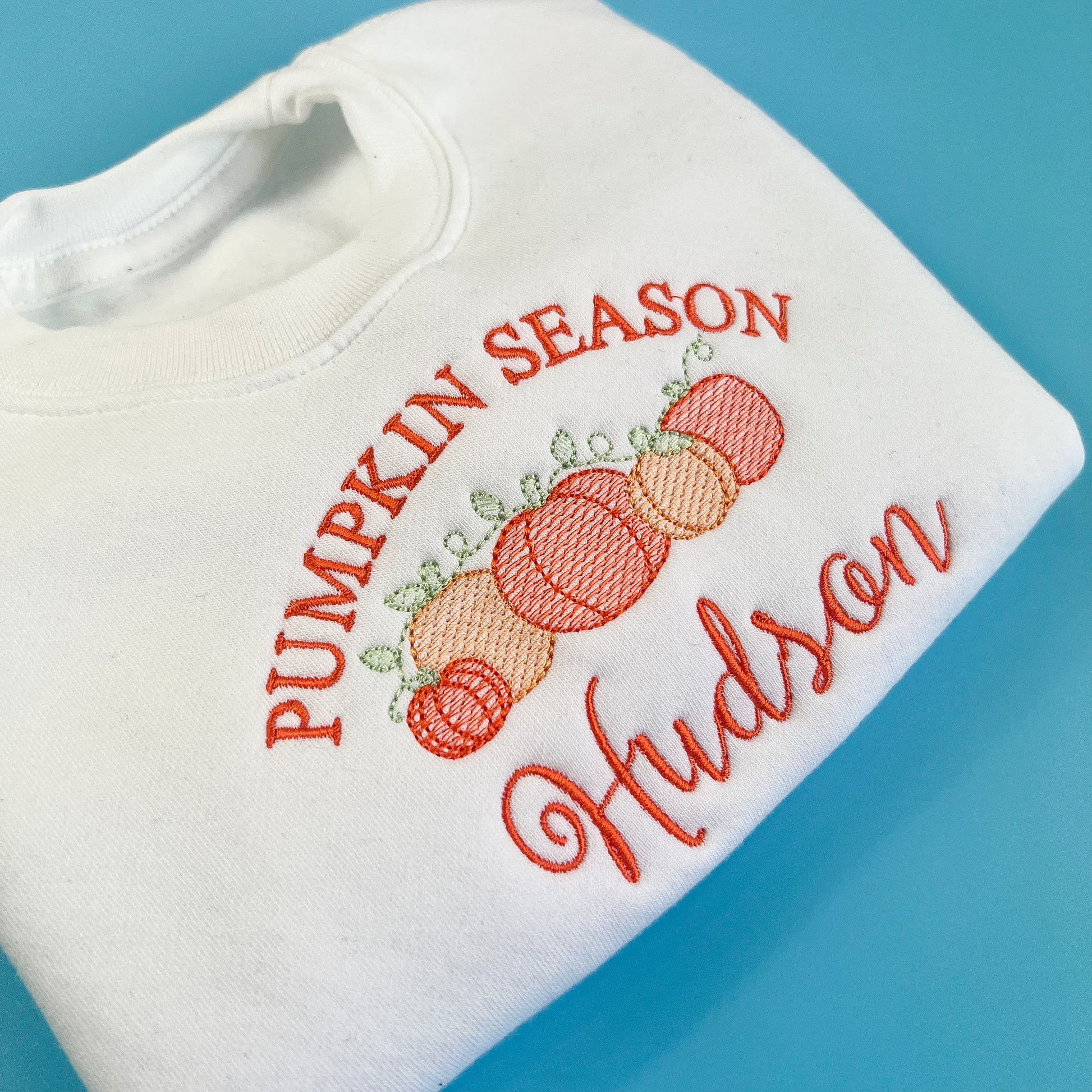 white jumper with pumpkin season in orange embroidery, with 5 pumpkins and childs name