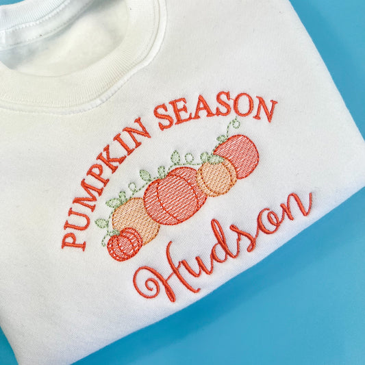 white jumper with pumpkin season in orange embroidery, with 5 pumpkins and childs name